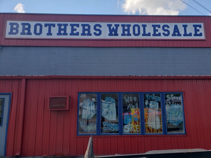 Brothers Wholesale sign above hand-painted appliance window art